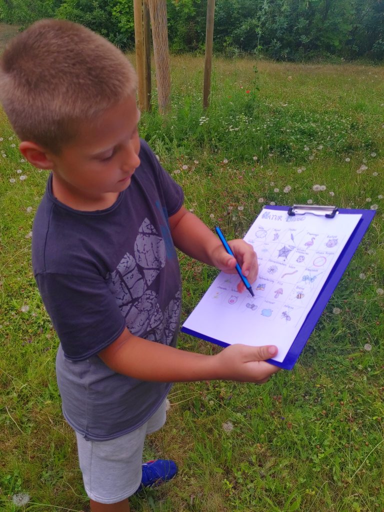 Ein Junge zeigt etwas mit einem Stift auf einem Klemmbrett