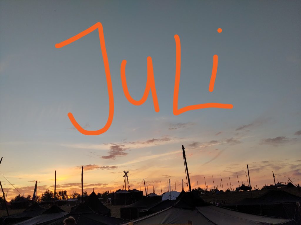 Schwarzzeltdächer im Sonnenuntergang, am Himmelt steht JULI